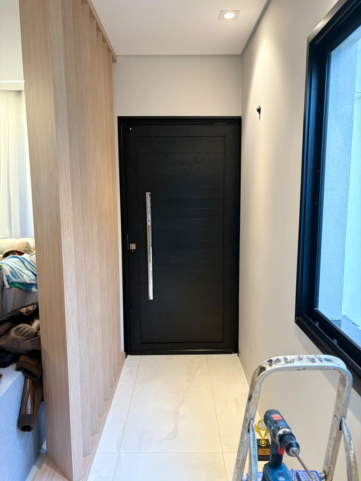 Porta pivotante preta com puxador em inox