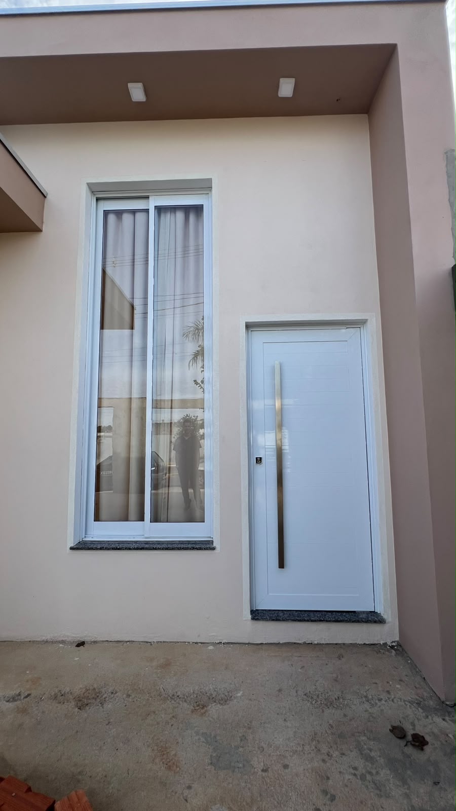 Fachada residencial com janela e porta de entrada em alumínio branco instaladas pela HELUX