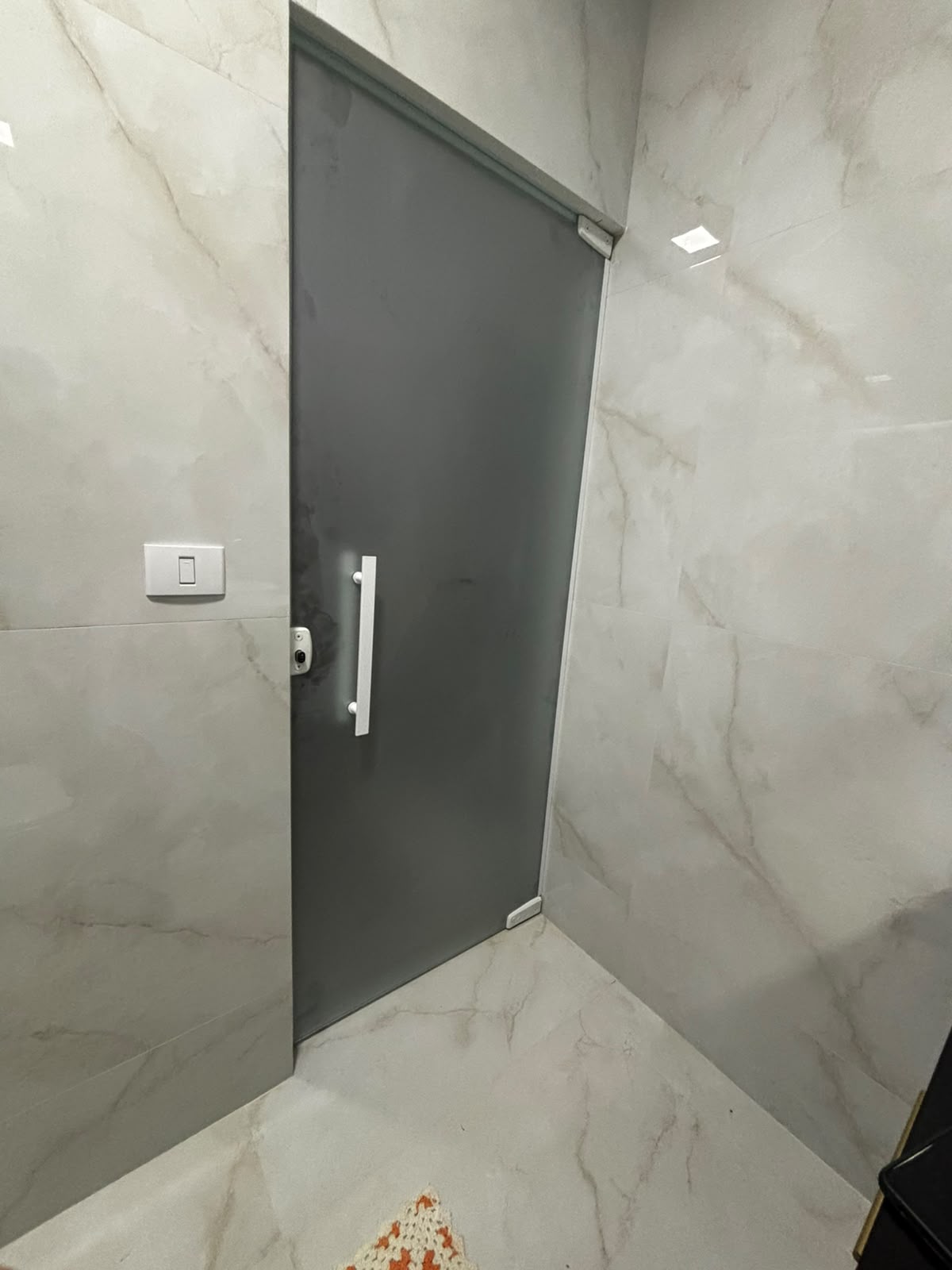 Porta de vidro fumê em banheiro porcelanato