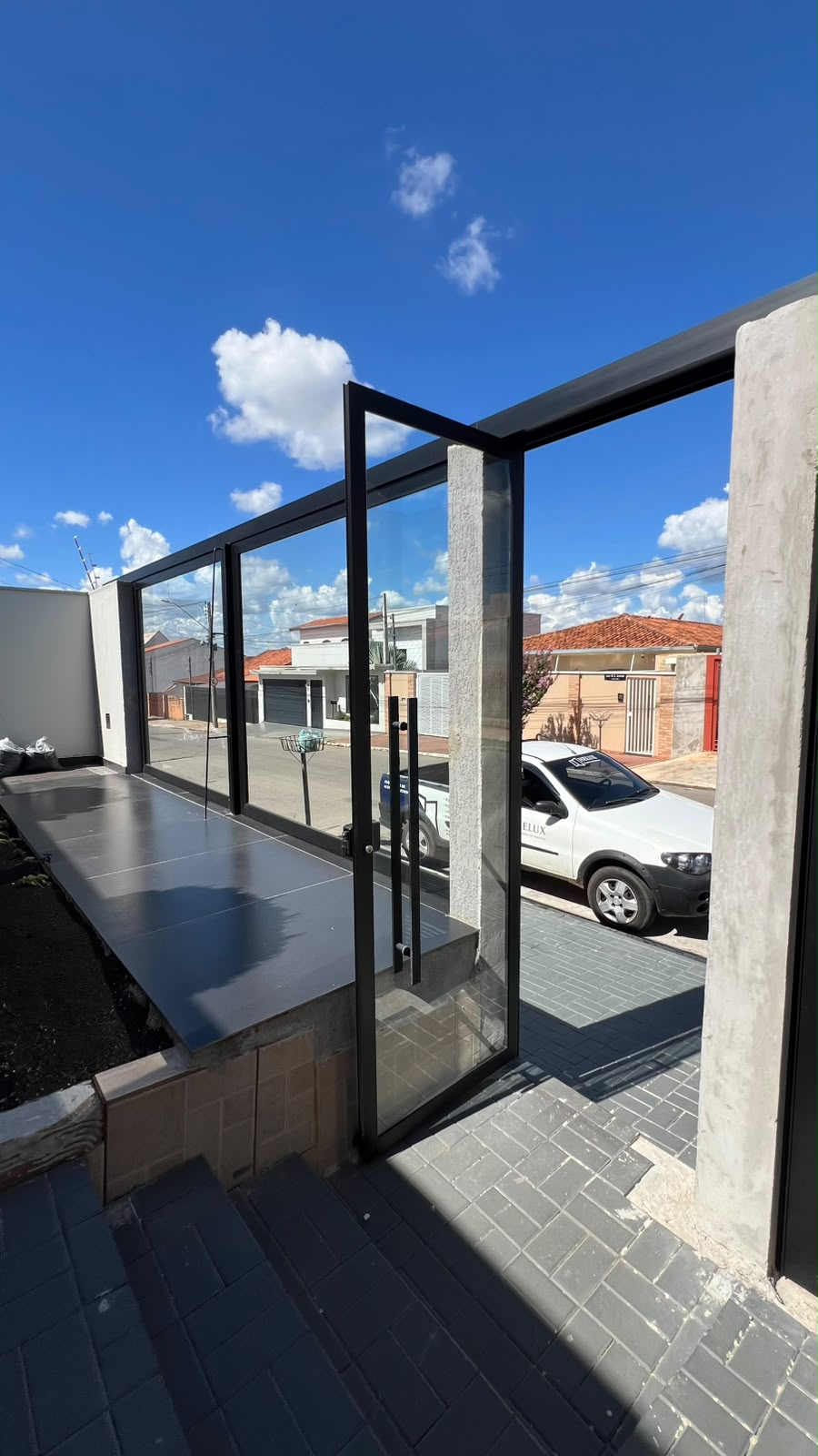 Porta pivotante em vidro e fechamento de fachada