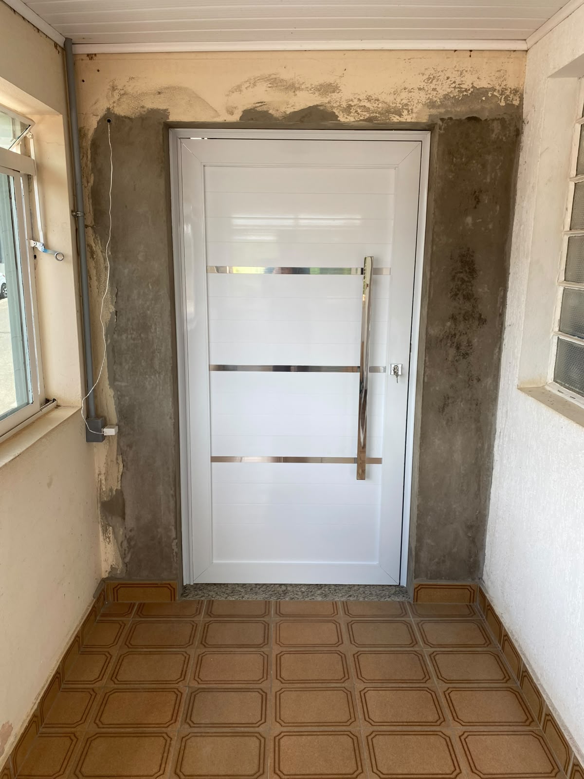 Porta de entrada lambril branca com frisos em inox